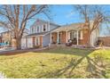 Lovely front exterior with brick accents, a manicured lawn, and a cozy front porch at 2079 S Quintero St, Aurora, CO 80013