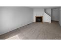 Living room with a brick fireplace, neutral carpet and access to the upper floor at 10248 Quivas St, Thornton, CO 80260