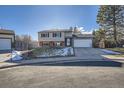 Tan two-story house with attached garage and driveway at 9150 W Bellwood Pl, Littleton, CO 80123