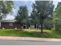 Charming brick home with manicured lawn, mature trees, and a welcoming front porch at 1158 E Easter Ct, Centennial, CO 80122
