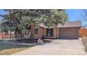 Single-Gathering house featuring a brick exterior, attached garage, and a mature tree in the front yard at 3960 Cody St, Wheat Ridge, CO 80033