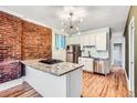 Bright kitchen with stainless appliances, granite counters, and exposed brick detail at 3726 N High St, Denver, CO 80205