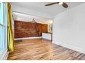Spacious living room with hardwood floors and exposed brick feature wall at 3726 N High St, Denver, CO 80205