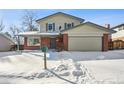 Two-story house with attached garage, visible in snowy landscape at 6663 Zinnia St, Arvada, CO 80004