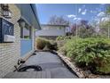 Private backyard featuring a well-kept patio area bordered by mature shrubs and a stone retaining wall at 7761 S Wellington St, Centennial, CO 80122