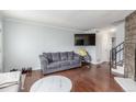 Cozy living room with hardwood floors, a gray sofa, and a modern TV mounted on the wall at 1622 S Idalia Cir # E, Aurora, CO 80017