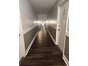 Hallway with wooden floors and neutral paint, leading to unit 114 and other units at 8330 Zuni St # 117, Denver, CO 80221