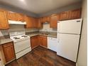 Kitchen with white appliances, wood cabinets and countertops and dark wood flooring at 8330 Zuni St # 117, Denver, CO 80221