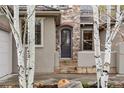 Close-up of the home's front door with stone and stucco accents at 15252 W Warren Dr, Lakewood, CO 80228