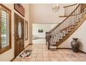 Grand foyer with staircase, decorative rug, and tile flooring leading to living spaces at 11412 W Roxbury Pl, Littleton, CO 80127