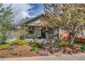 Cozy home with landscaped yard, mature tree, and covered front porch at 4456 Yates St, Denver, CO 80212