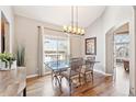 Bright dining room with hardwood floors, stylish chandelier, and picturesque window views at 7141 S Versailles St, Aurora, CO 80016