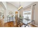 Elegant dining room featuring hardwood floors, modern chandelier, and a large window at 7141 S Versailles St, Aurora, CO 80016