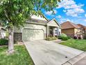 Well-maintained home exterior, features a driveway, a partial lawn, and nice stone details at 11556 W Cooper Pl, Littleton, CO 80127