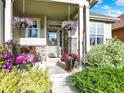 Inviting front porch with stone columns, decorative plants, and seating area at 11556 W Cooper Pl, Littleton, CO 80127
