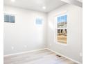 Sunlit bedroom with neutral walls, white trim, and large windows offering neighborhood views at 779 N Tempe St, Aurora, CO 80018