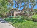 Spacious home with lush green lawn, mature trees, and manicured landscaping at 3540 E 5Th Ave, Denver, CO 80206