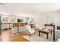 Inviting living room with hardwood floors, a breakfast bar, and elegant, neutral-toned furniture at 2213 E Panama Dr, Centennial, CO 80121