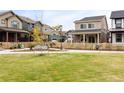 A neighborhood park is visible, with green grass, a sidewalk, and a picket fence lined with shrubs at 129 Mesa Way, Superior, CO 80027