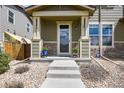Inviting entrance to home, with flower pots on porch, rock landscaping and concrete stairs at 1273 S Dallas Ct, Denver, CO 80247