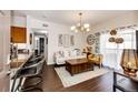 Stylishly decorated living room featuring a modern chandelier, comfortable seating, and an open layout to the kitchen at 5439 S Dover St # 101, Littleton, CO 80123