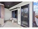 Inviting front porch with seating, a modern black door, and stylish exterior details at 1250 Yates St, Denver, CO 80204