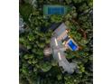 Aerial view showcasing a private tennis court and backyard pool with surrounding trees at 4766 S Fillmore Ct, Cherry Hills Village, CO 80113
