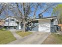 Charming gray split-level home with attached garage and mature trees at 1524 Twin Sisters Dr, Longmont, CO 80504