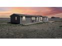 Dusk view of home showcasing updated exterior and landscaping at 62681 E Hampden Pl, Byers, CO 80103