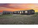 View of the side exterior of the house with detached garage at 62681 E Hampden Pl, Byers, CO 80103