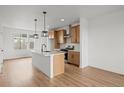 Modern kitchen featuring an island, stainless steel appliances, and wood cabinets at 2736 W 68Th Ave, Denver, CO 80221
