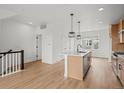 Bright, open kitchen with stainless steel appliances, an island and light wood floors at 2736 W 68Th Ave, Denver, CO 80221
