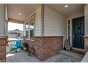 Inviting covered front porch with decorative stone accents and a cozy seating area at 8255 S Vandriver Way, Aurora, CO 80016