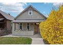 Charming bungalow-style home featuring a cozy front porch and fresh exterior paint with craftsman details and vibrant landscaping at 953 Kalamath St, Denver, CO 80204