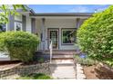 Inviting front porch with decorative columns, a security system sign, and landscaped flower beds at 12277 W Chenango Dr, Morrison, CO 80465