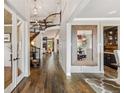 Grand foyer featuring hardwood floors, a curved staircase, and elegant decorative mirror at 21962 E Idyllwilde Dr, Parker, CO 80138