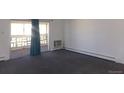 Carpeted living room with large window and access to an enclosed balcony at 580 S Clinton St # 10D, Denver, CO 80247
