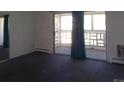 Spacious carpeted living room with access to an enclosed balcony at 580 S Clinton St # 10D, Denver, CO 80247