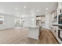 Open floor plan featuring a large kitchen island with white cabinetry and modern stainless steel appliances at 9253 Truckee Ct, Commerce City, CO 80022