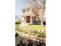 Lovely two-story home featuring a covered front porch, well-maintained lawn, and colorful flower beds at 3905 Tejon St, Denver, CO 80211