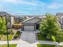 Aerial view of a charming single-Gathering home with two-car garage, stone accents and a well-kept lawn at 9628 Albion Ln, Thornton, CO 80229