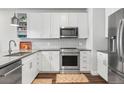 Well-lit kitchen with stainless steel appliances, white cabinets and subway tile, showcasing modern design at 20 Wilcox St # 403, Castle Rock, CO 80104