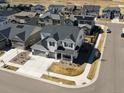 Expansive aerial view of a white two-story home, landscaped front yard, and located in a neighborhood at 904 Sundown Way, Erie, CO 80516