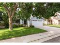 Charming two-story home with a manicured lawn, mature trees, and a two-car garage on a sunny day at 19135 E Hickock Dr, Parker, CO 80134