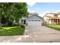 Charming blue two-story home with a two-car garage, front lawn, and mature trees, creating an inviting curb appeal at 19135 E Hickock Dr, Parker, CO 80134