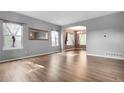 Spacious living room with light gray walls, wood floors, large windows, and elegant archway leading to dining area at 19135 E Hickock Dr, Parker, CO 80134