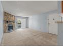Cozy living room features a stone fireplace, neutral carpet, and sliding door to a balcony at 1792 S Pitkin Cir # B, Aurora, CO 80017