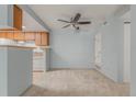 Well-lit open concept living room with ceiling fan and view into the kitchen at 1792 S Pitkin Cir # B, Aurora, CO 80017
