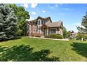 Attractive exterior view highlighting green front lawn and mature trees at 6825 S Webster St # A, Littleton, CO 80128