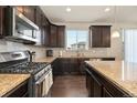 Well-equipped kitchen boasting granite countertops, stainless steel appliances, and dark wood cabinetry at 9486 Juniper Way, Arvada, CO 80007